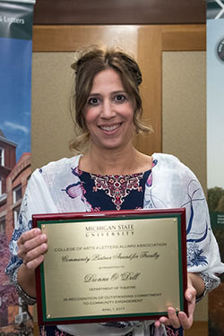 portrait of a woman with brown eyes holding award